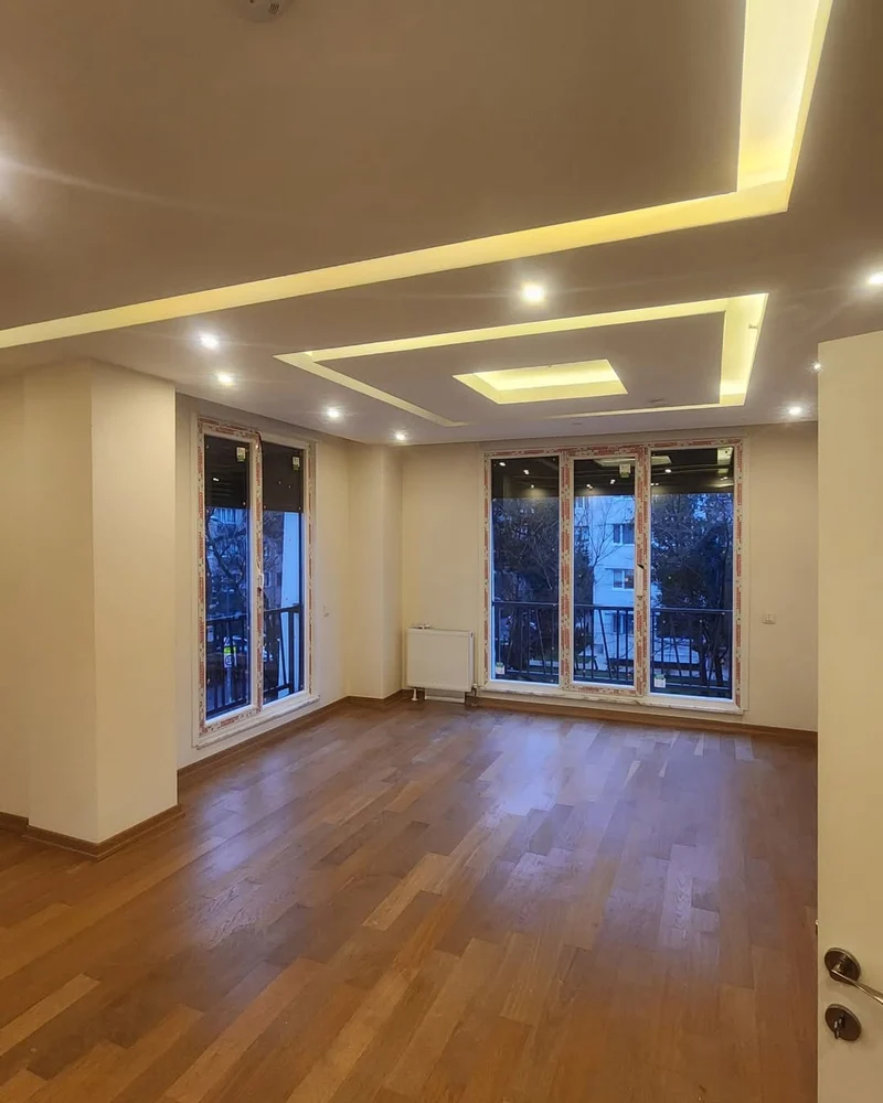 Beyaz PVC profilli pencereleri ve balkon kapısı bulunan iç mekân
